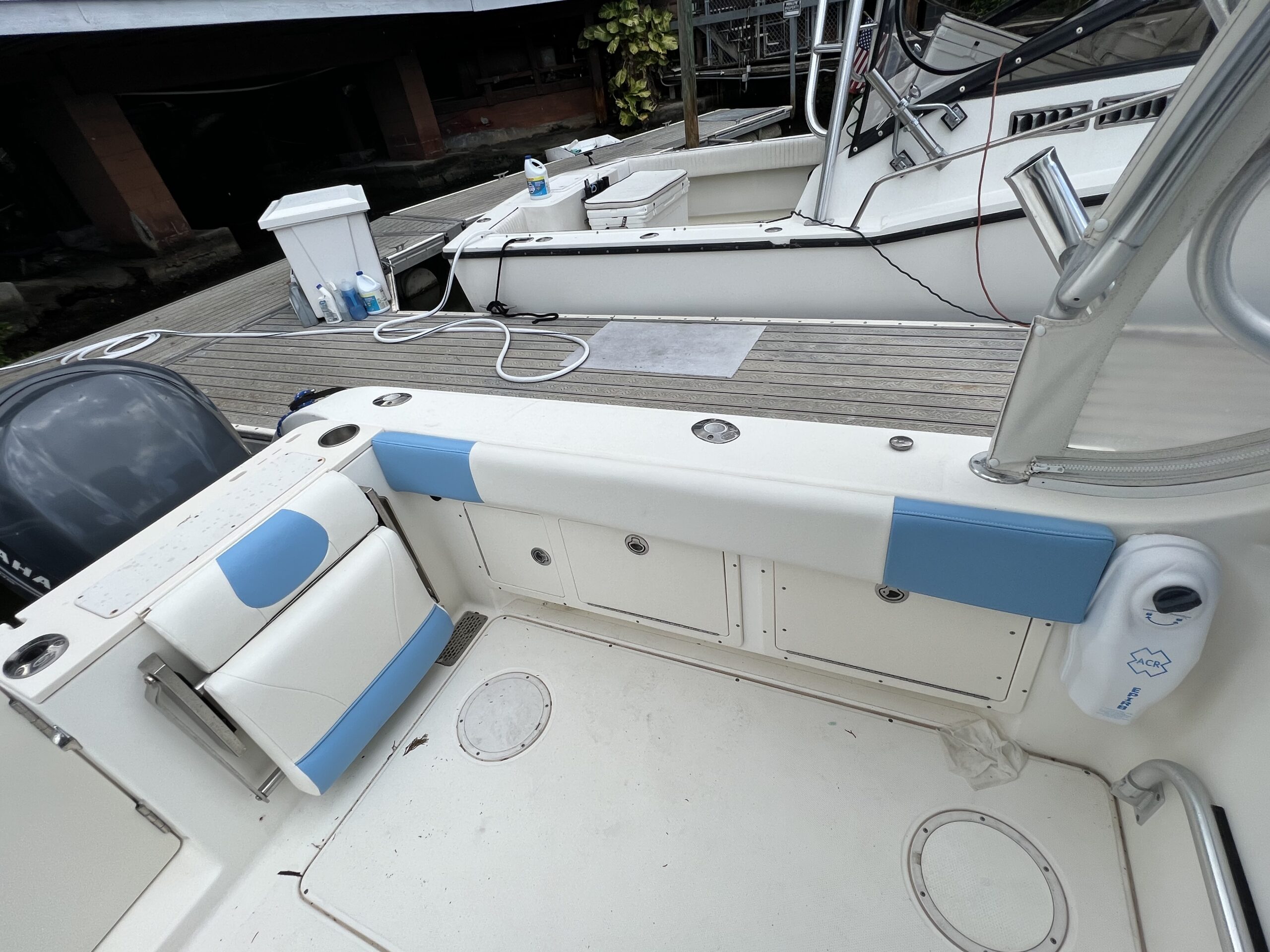 Sarasota boat interior showing sun-damaged blue and white seating cushions, a common candidate for professional marine upholstery repair